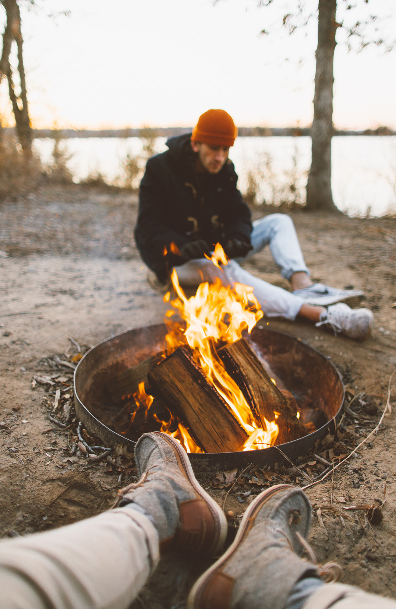 Reizigers aan een kampvuur tijdens een overland tour met een truck