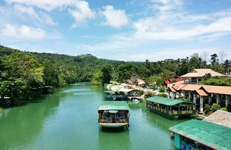 Brede boten met een groen dak op een rivier op Cebu Island