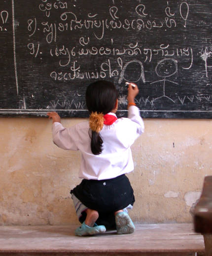Schoolmeisje in Laos die op bord schrijft