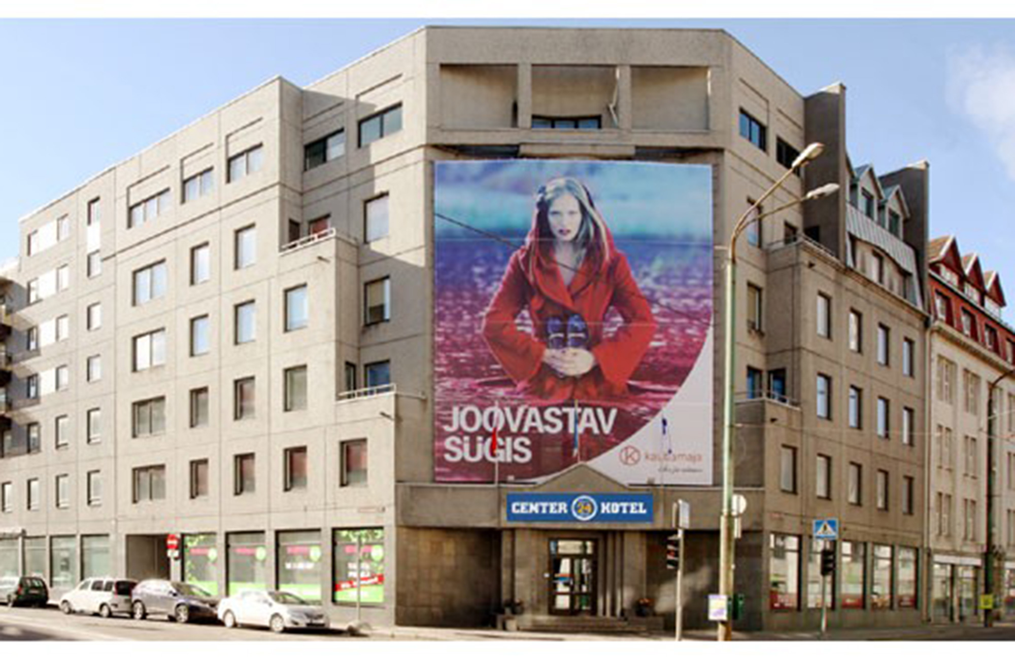 Het hoekgebouw van Center Hotel in Tallinn met een grote reclameposter op de gevel.