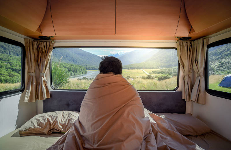 Persoon in camper met zicht op natuur