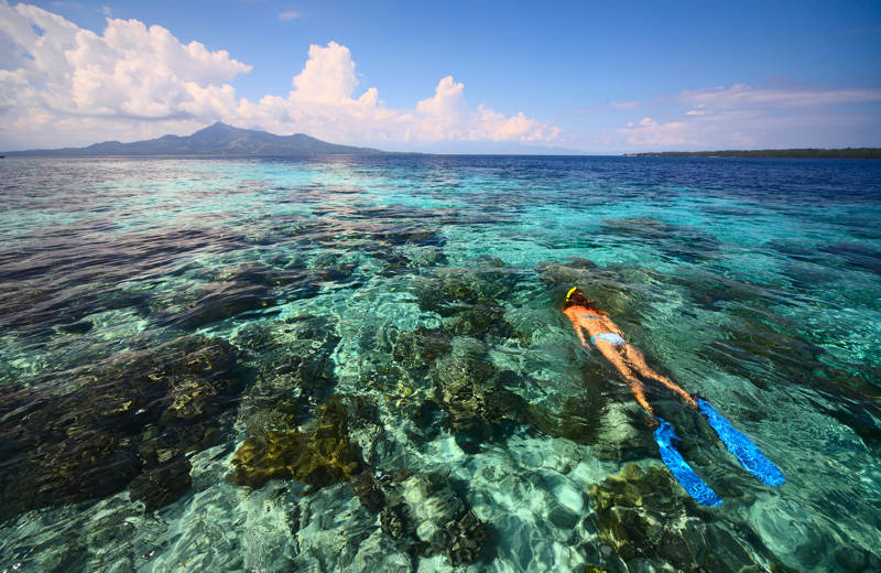 Meisje met blauwe zwemvliegen zwemt aan de kust van Sulawesi in Indonesië