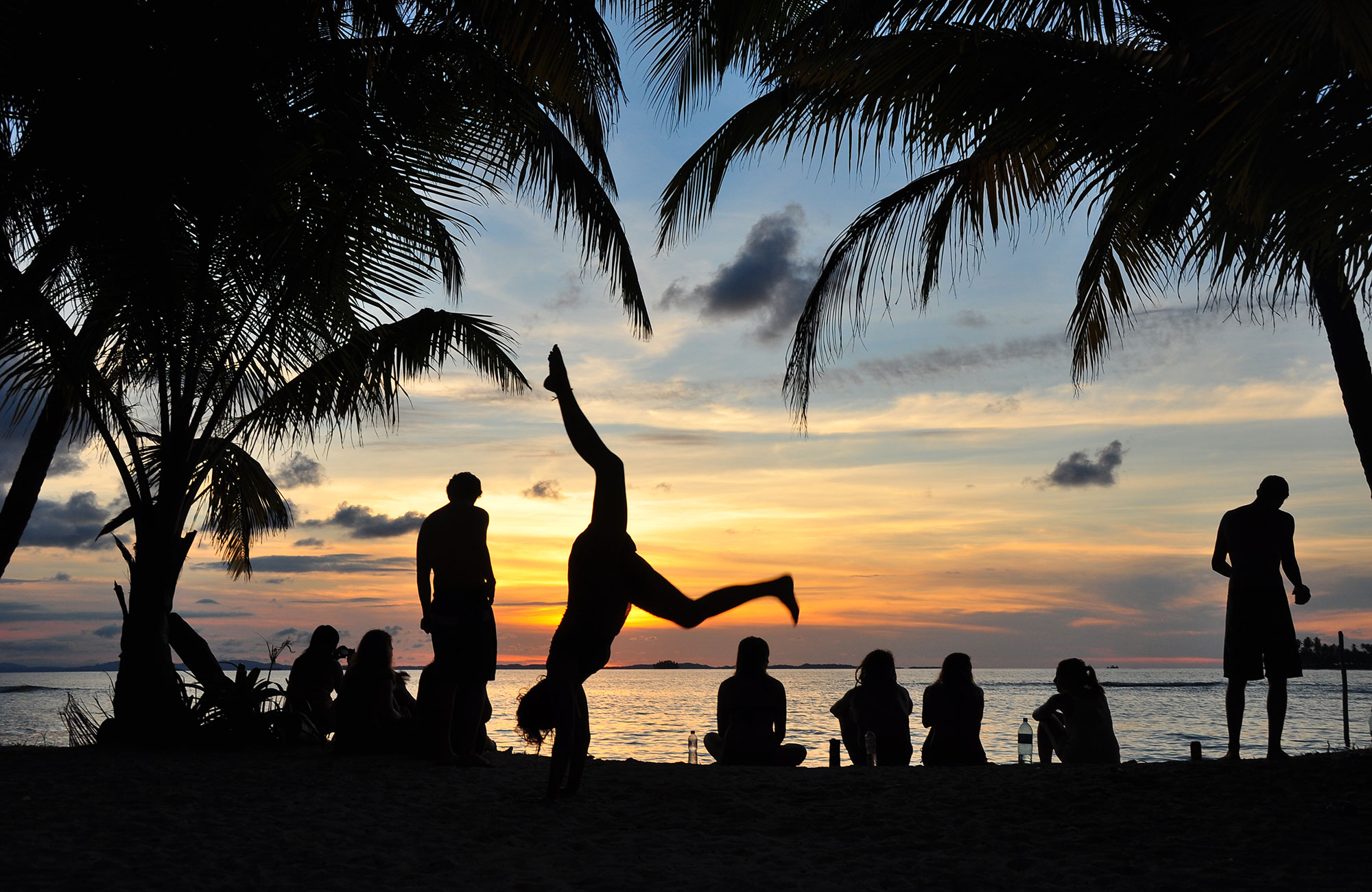 Silhouetten van reizigers op het strand | Reis met de bus door Midden-Amerika | Bamba Experience | KILROY