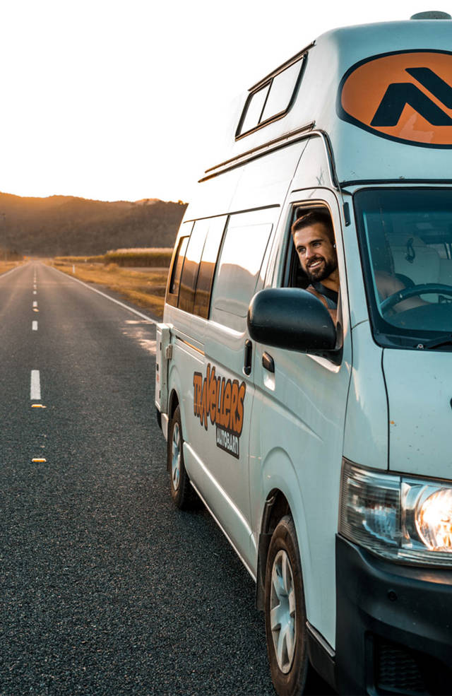 Reiziger kijkt uit het raam van de Hi5 Camper | Camperhuur Australië | KILROY