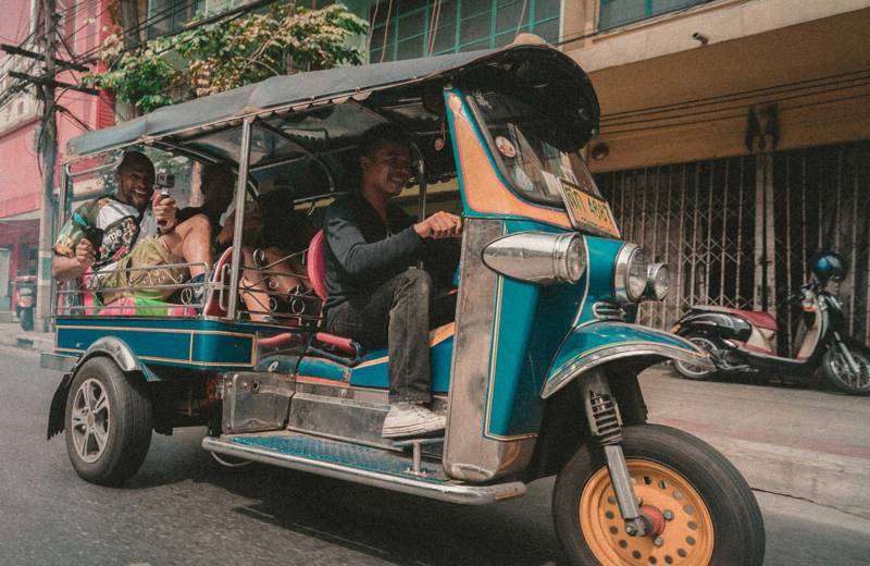 Twee backpackers op een TukTuk in Azië