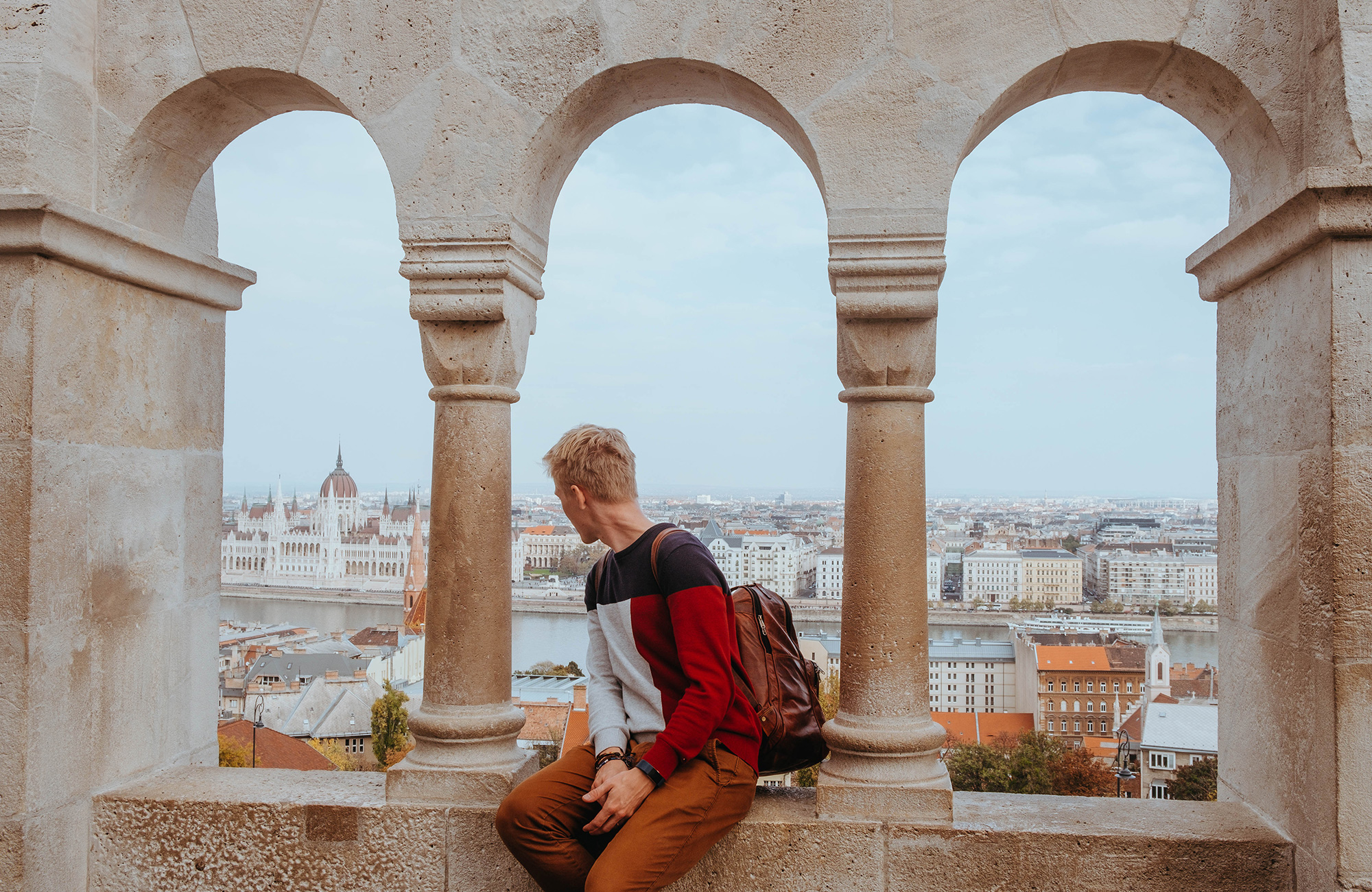 Jonge man geniet van het uitzicht op Buda Castle tijdens een studiereis naar Boedapest