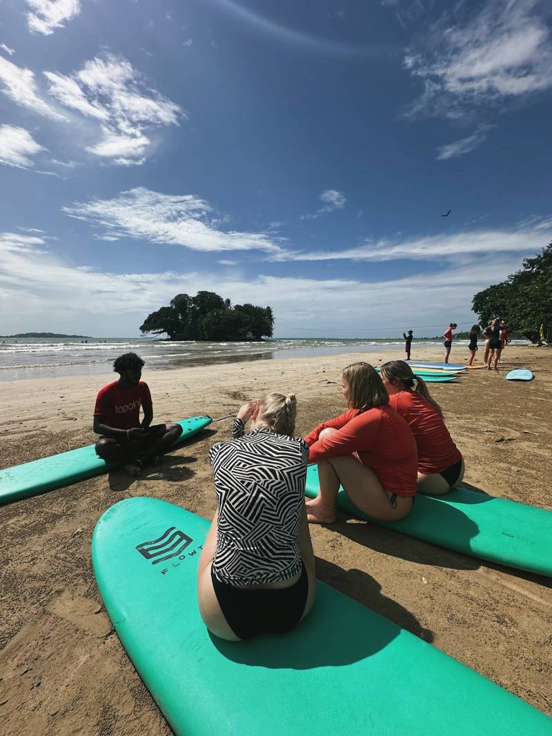Meisjes volgen surfles op het strand in Sri Lanka