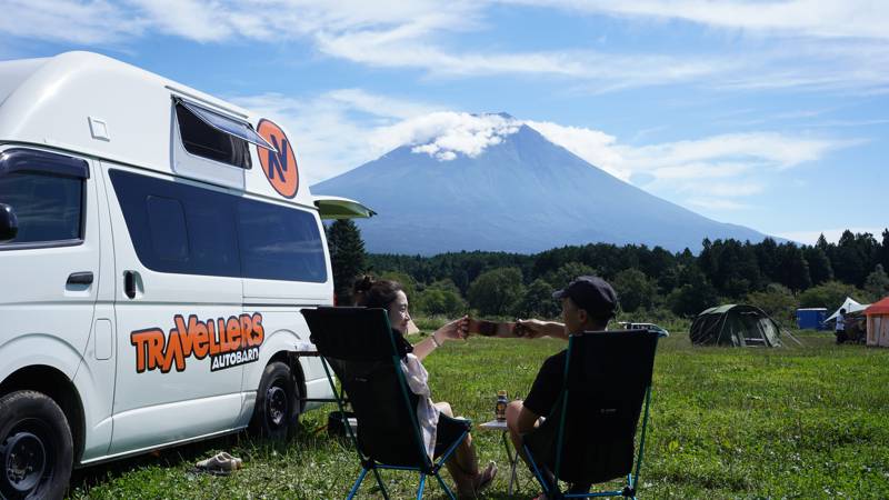 Campervan op een camping in Japan, met een vulkaan in de achtergrond