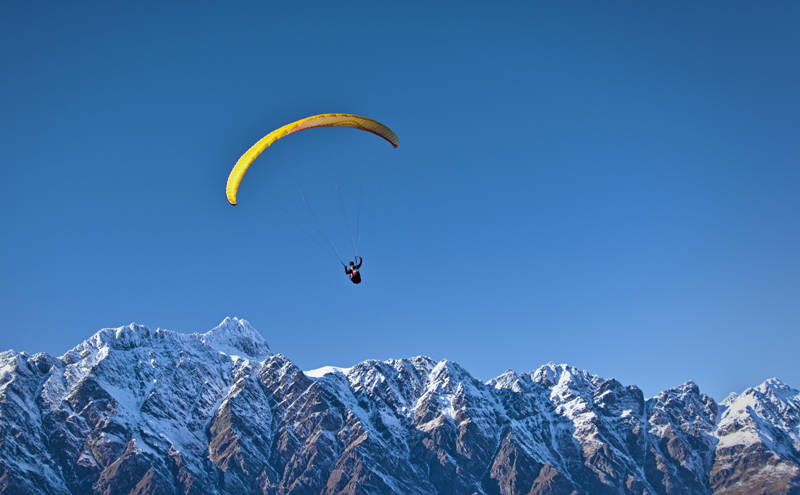 Paragliding over de besneeuwde bergtoppen bij Queenstown in Nieuw-Zeeland