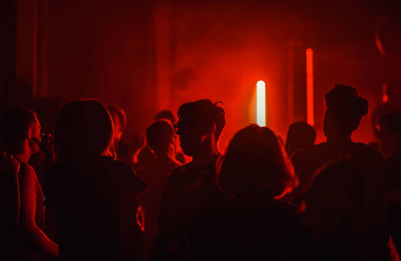 Jongeren op een feestje met rode lichten op de achtergrond