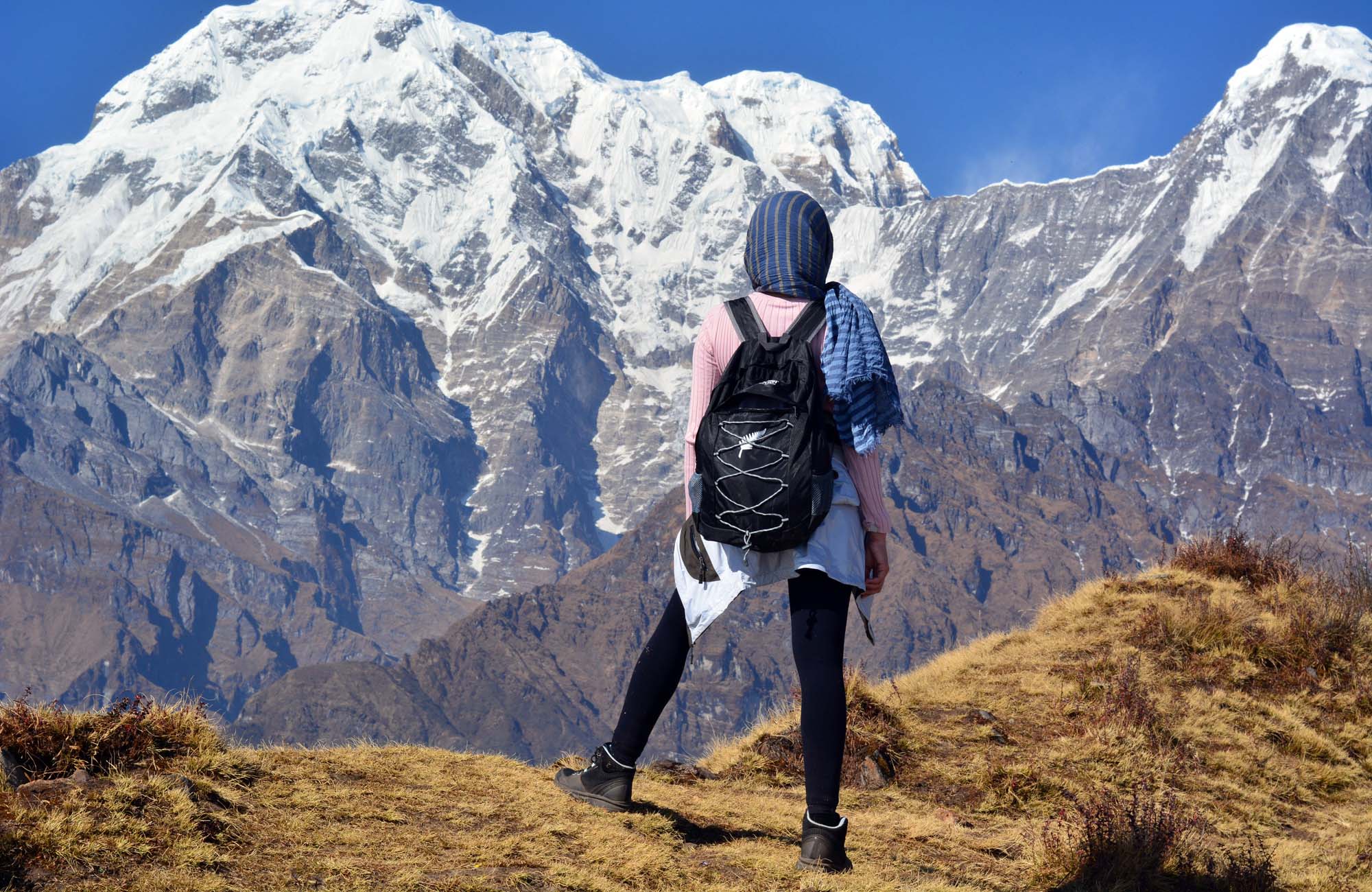 Jonge vrouw die door de schilderachtige bergen van Pokhara, Nepal, trekt, omringd door weelderige natuur en adembenemende uitzichten op de Himalaya
