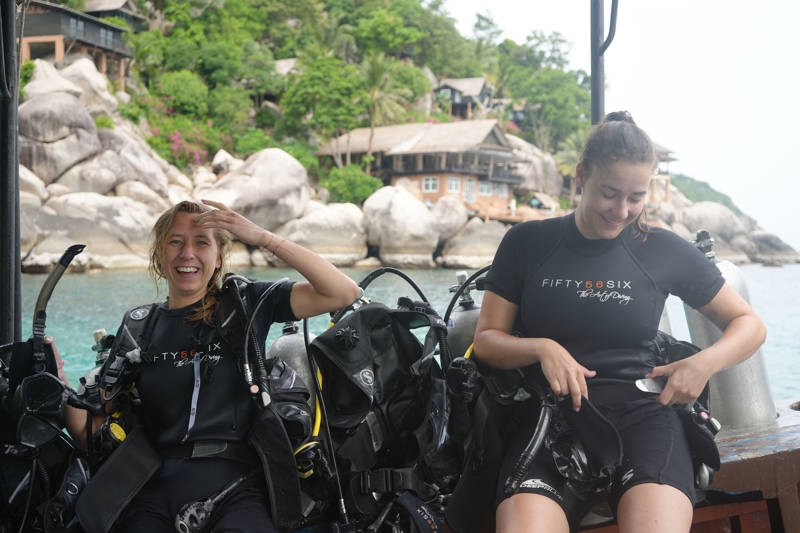 Twee meisjes op een boot in Thailand glimlachen nadat ze een duik hebben genomen in het water van Koh Tao.