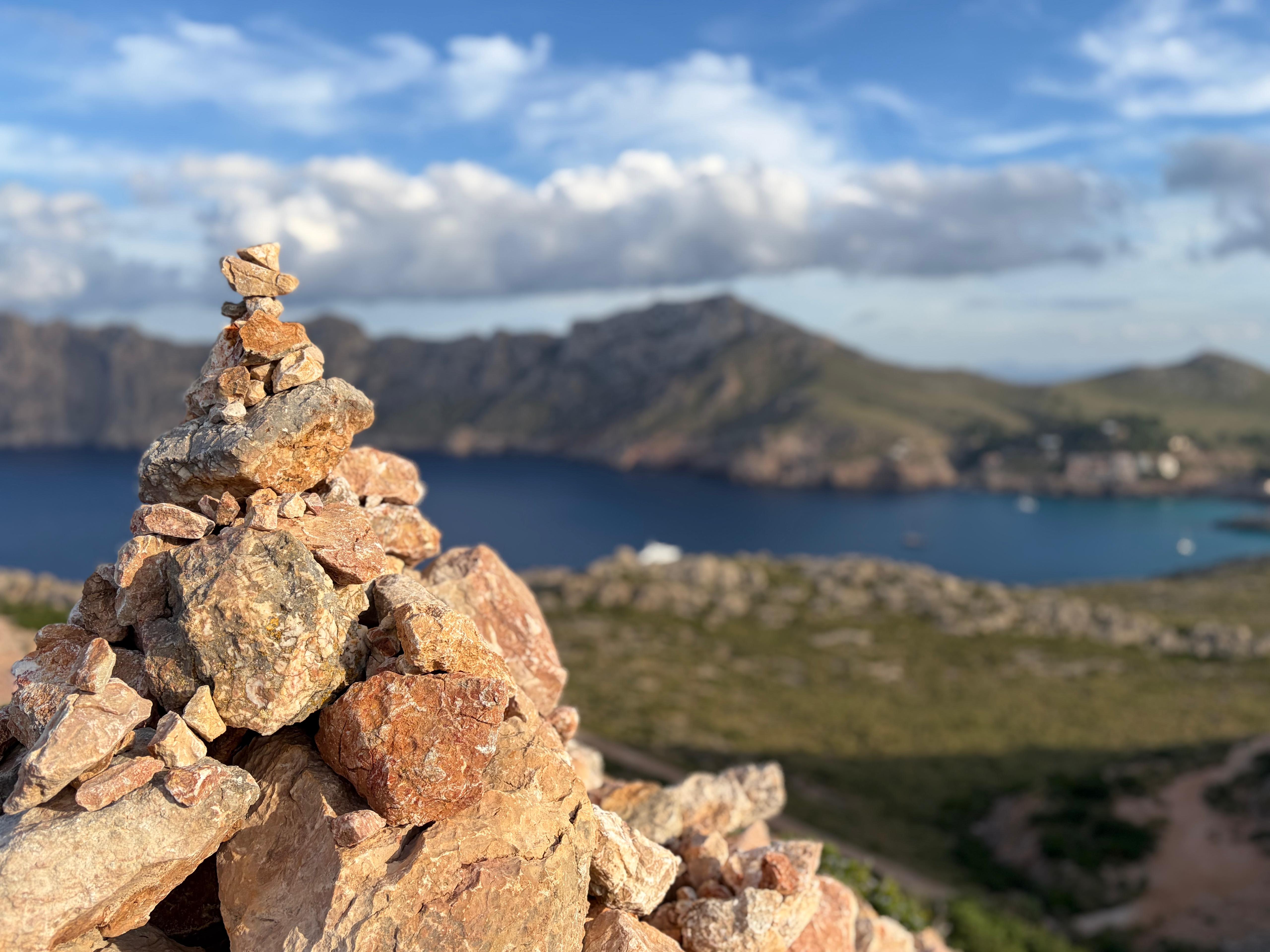 Een cairn (stenen stapel) op de bergkam van Cap de Formentor, Mallorca, met uitzicht op de Middellandse Zee en de baai tijdens een crossfit bootcamp.