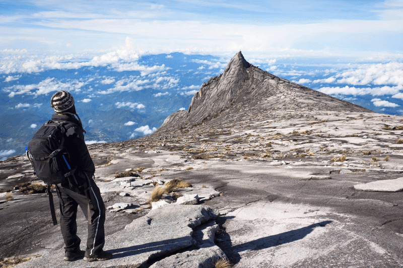 Man in het zwart op de top van de Mount Kinabalu in Borneo