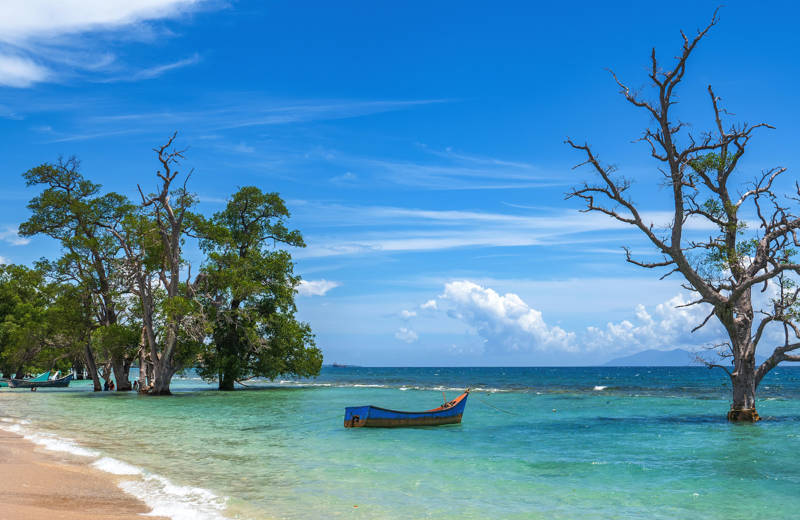 White sandy beach with small wooden board on Sumatra in Indonesia