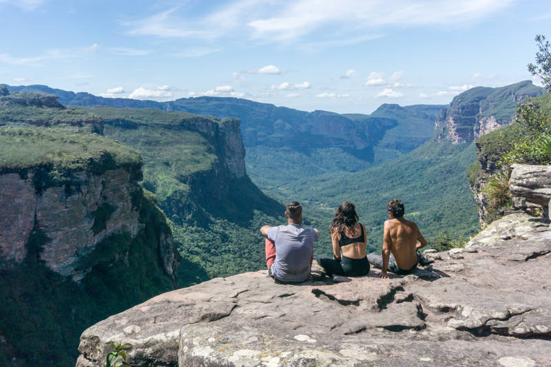Reizigers zitten op een klif en kijken naar het panoramisch uitzicht over Chapada Diamantina National Park in Brazilië