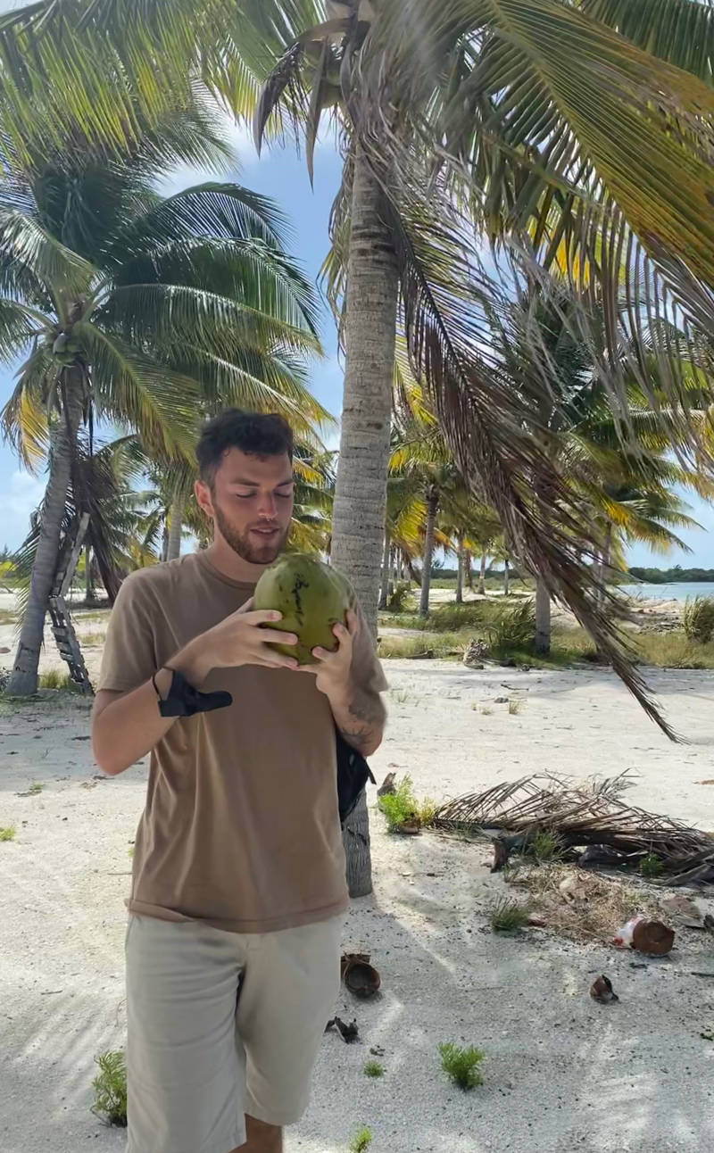 Abel met een kokosnoot in Caye Caulker in Belize